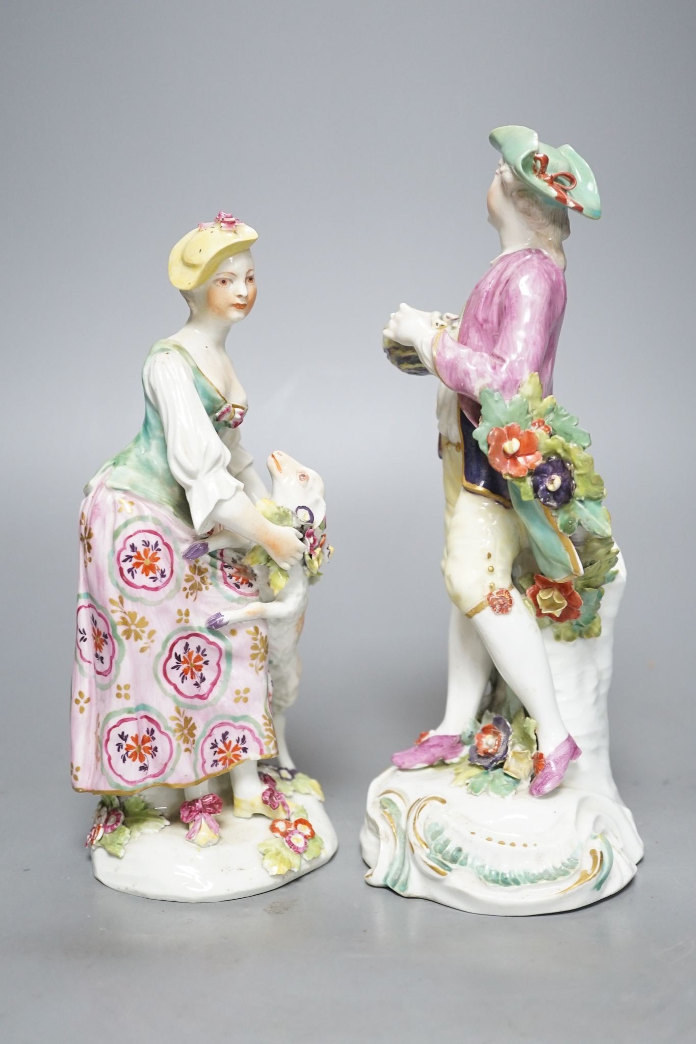 Two Derby porcelain figures of a gentleman holding a bird’s nest and a lady with a sheep, c.1760, 21.5 cms high.